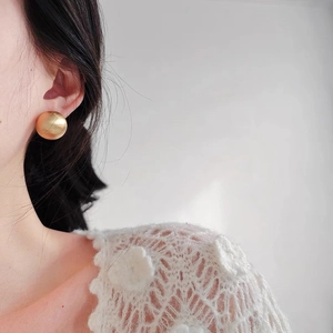 Minimalist matte gold spherical stud earrings for women shown on model for daily style