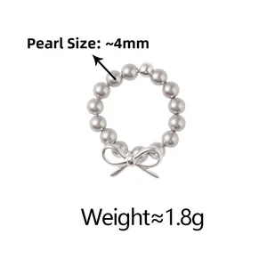 Détail d'une bague en perles blanches de 4mm avec nœud métallique et poids du bijou