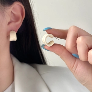 Minimalist cream white C-shaped stud earrings with a glossy finish for a modern summer look