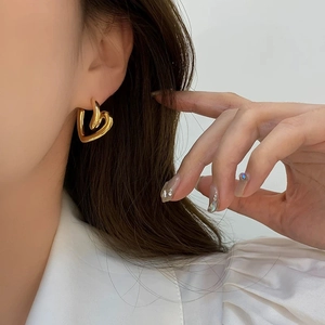 Elegant gold double heart-shaped earrings on model for stylish everyday wear