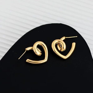 Macro shot of minimalist gold heart earrings with high-polish twisted streamline design