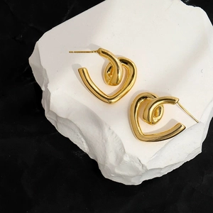 Detailed view of gold heart-shaped stud earrings with unique cross-wrapped geometric design