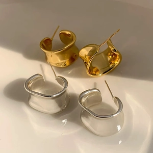 Minimalist C-shaped irregular wide stud earrings in polished gold and silver metal finishes