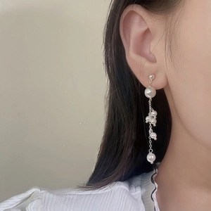 Elegant long pearl tassel drop earrings with silver metal chains on a female model
