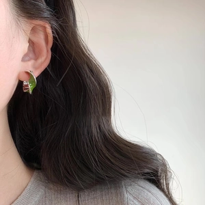 Silver Mobius hoop earrings with green enamel glaze finish on female model