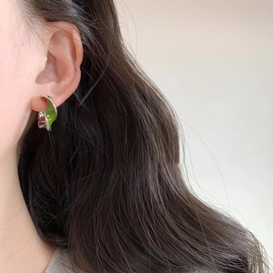 Elegant silver Mobius loop earrings with green enamel on a model for a chic look