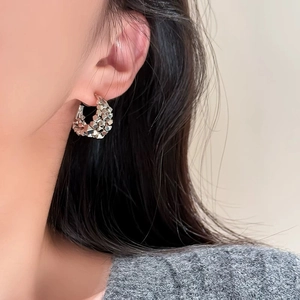 Detailed view of silver layered hoop earrings with textured geometric facets on model