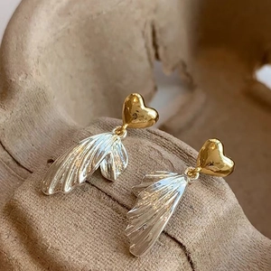 French style gold heart stud earrings with silver wing tassels on a rustic ceramic stand