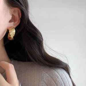 Chic gold-tone hoop earrings with a twisted texture shown on a female model
