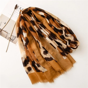 Detail view of cotton leopard print scarf with fine fringe edges and chic color block pattern