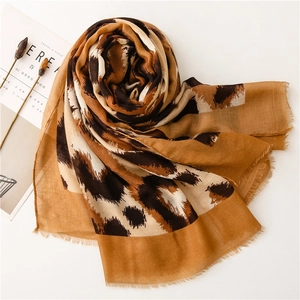 Detailed view of leopard print cotton linen scarf with soft fringe edges and caramel tones