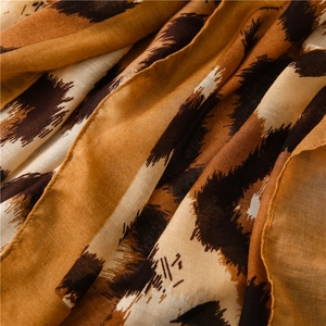 Close-up of leopard print scarf fabric showing soft cotton linen texture and brown colors