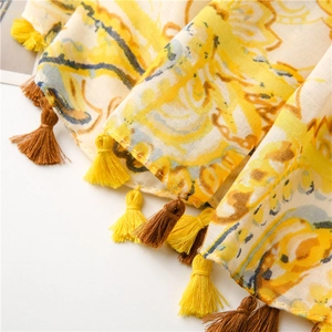 Detail of bohemian yellow cotton linen scarf with vintage paisley print and bicolor tassels