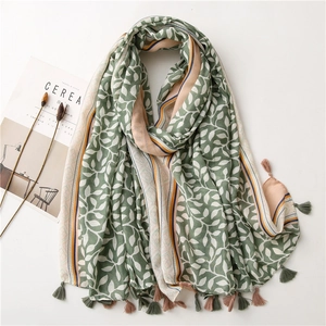 Detail of soft linen scarf with green leaf print and fringe trim for sun protection