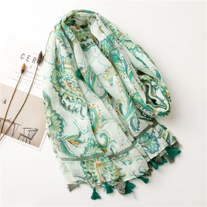 Detail of bohemian paisley print scarf with dark green tassels and soft linen texture