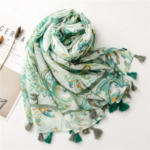 Detail of bohemian cotton linen scarf featuring paisley print and green tassel edges