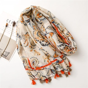 Close-up of bohemian paisley printed scarf with colorful tassels and soft linen texture