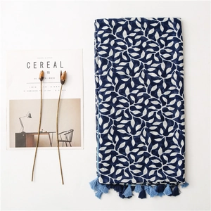 Detail of dark blue scarf with white leaf patterns and bi-color fringe tassels