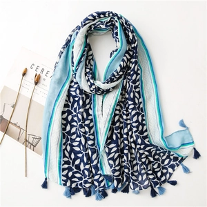 Detailed view of lightweight linen scarf with leaf print and tassel pendant fringes