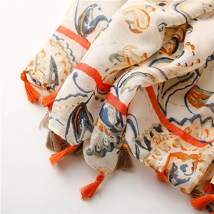 Macro detail of bohemian paisley print on cotton linen scarf with two-tone tassels