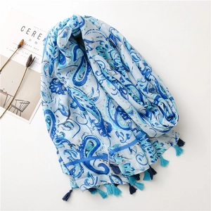 Detail of light blue paisley print scarf with dual-tone tassels on white background