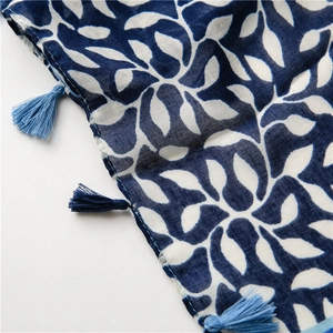 Detail of soft cotton linen scarf featuring blue grape leaf patterns and light blue tassels