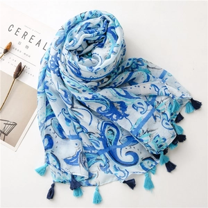 Detail view of blue paisley linen scarf with decorative fringe and boho floral patterns