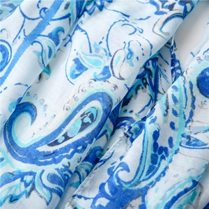 Macro view of blue and white paisley pattern on lightweight semi-transparent fabric