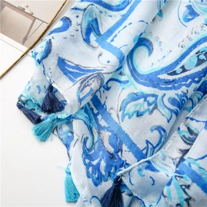 Close-up of blue paisley cotton linen scarf featuring delicate fringe tassels and textures