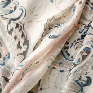 Macro view of paisley print on cotton linen scarf with soft pink and blue ethnic patterns