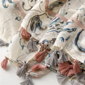 Detailed macro view of bohemian paisley print cotton linen scarf with pastel tassels
