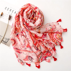 Close-up of pink Bohemian cotton linen scarf with elegant paisley prints and tassel edges