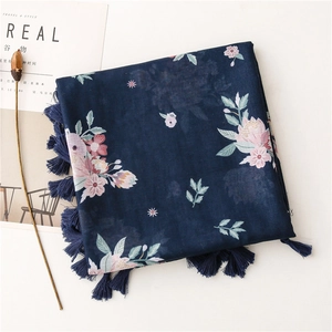 Detail of dark blue floral scarf with soft fringes and artistic flower patterns