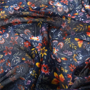 Detail of floral and dragonfly prints on soft dark blue cotton linen fabric texture