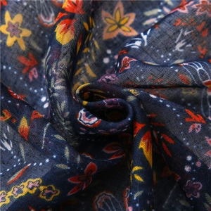 Macro detail of ethnic floral print fabric with deep blue base and fringe texture