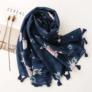 Detailed view of floral navy blue scarf with soft fringe edges on a minimalist background