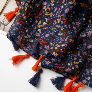 Macro detail of navy floral cotton linen scarf with colorful tassel fringe edges