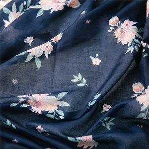 Detailed view of dark blue floral scarf fabric with soft texture and delicate prints