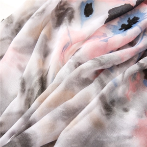 Detailed close-up of soft floral tie-dye scarf fabric with elegant raw edges and texture
