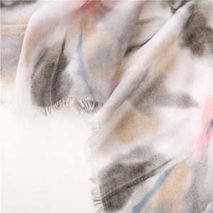 Close-up of soft lightweight scarf featuring colorful tie-dye patterns and frayed edges