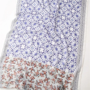 Detail of blue mandala and orange floral print patterns on soft cotton linen scarf