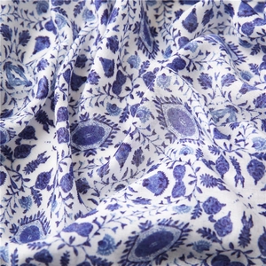 Macro detail of blue floral cotton scarf fabric with elegant ethnic patterns