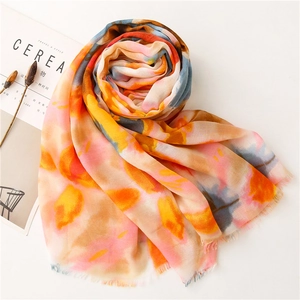 Long scarf with colorful floral print and raw fringe edges in watercolor style