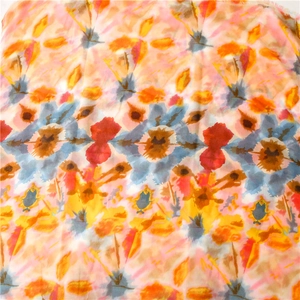 Close-up of soft lightweight long scarf featuring colorful abstract dye patterns and raw edges
