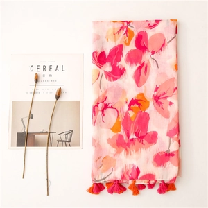 Detail view of floral print scarf with pink and orange patterns and fringe tassels