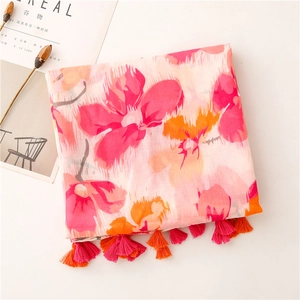 Detailed view of large floral print on cotton-linen scarf with bicolor tassel edge
