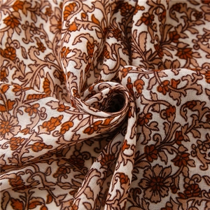 Macro detail of bohemian floral cotton linen fabric with soft orange flower patterns