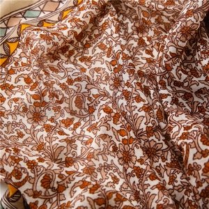 Macro shot of cotton linen scarf showing soft floral patterns and breathable fabric texture