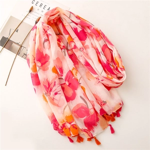 Detailed view of floral patterns and matching tassel fringe on a soft lightweight scarf