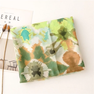 Artistic abstract watercolor scarf with green and yellow dye patterns on thin fabric